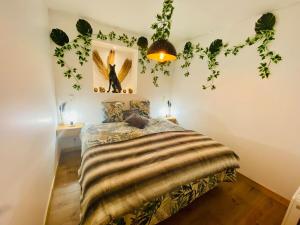 a bedroom with a bed with leaves on the wall at Ici, dort un Gorille in Planay +21 photos