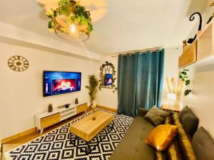 a living room with a couch and a tv at Ici, dort un Gorille in Planay