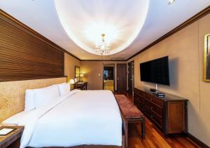 ein Schlafzimmer mit einem großen Bett und einem Flachbildfernseher in der Unterkunft Koreana Hotel in Seoul