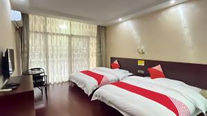 Duas camas com lençóis vermelhos e brancos num quarto em Zhangjiajie Alin Recreation Villa em Zhangjiajie