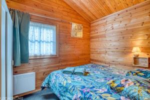 sypialnia z łóżkiem w drewnianym domku w obiekcie Chalet 17 tournesol Mauroux w mieście Mauroux +22 zdjęcia