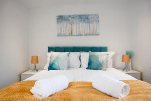 a bedroom with a large bed with towels on it at Luxury Solihull 6 bed 3 bath house 16 guests JLR HS2 BHX in Sheldon