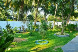 a garden with a hose laying on the grass at Coconut Resort Arugambay in Arugam Bay