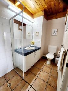 a bathroom with a sink and a toilet at Ocean Breeze Loft Villa With Pool, Tennis Court & Playground! in Mandurah