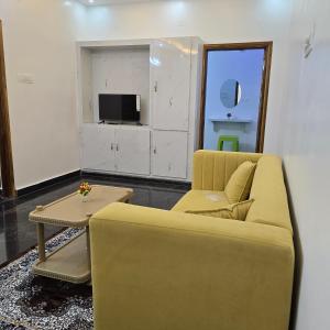 a living room with a yellow couch and a table at Padmini's home stay New apartment 2bhk in Tirupati