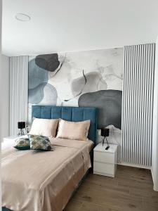 una camera con un letto blu e un dipinto sul muro di Villa Carpe diem a Vodice