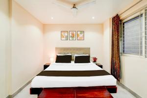 a bedroom with a large bed and a window at Super Hotel O Koramangala Near Sony Signal in Bengaluru