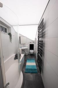 un bagno con vasca, WC e lavandino di Ring48 City Living - modernes Wohnen mit Wohlfühlambiente mitten im Stadtzentrum - vollausgestattete Küche, Bad mit Duschbadewanne, Parkplatz a Bayreuth