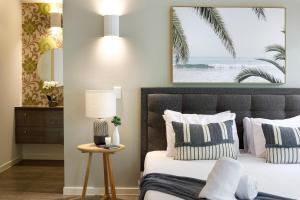 een slaapkamer met een bed met een foto van het strand bij Prime Location, Views & Sunsets, Walk to Hastings in Noosa Heads