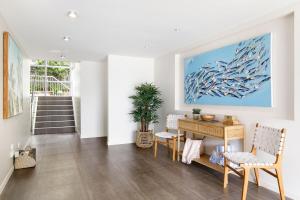 een eetkamer met een tafel en een schilderij van een vis aan de muur bij Prime Location, Views & Sunsets, Walk to Hastings in Noosa Heads