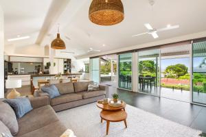 een woonkamer met een bank en een tafel bij Prime Location, Views & Sunsets, Walk to Hastings in Noosa Heads