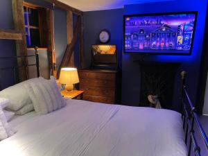 a bedroom with a bed and a flat screen tv at Spacious Cabin with Private Hot Tub, and Private Pool, in 5 Acres - intimate Special stay For 2 Adults - plus 1 child under 2 and up to 2 dogs stay for free in Downham +25 photos