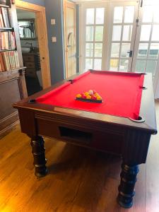 a pool table with a red cover in a room at Spacious Cabin with Private Hot Tub, and Private Pool, in 5 Acres - intimate Special stay For 2 Adults - plus 1 child under 2 and up to 2 dogs stay for free in Downham