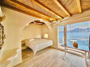 Utopia boutique villa on-in the water between 2 seas ideal 5 people في Kástron: غرفة نوم مع سرير وإطلالة على المحيط +25 صورة