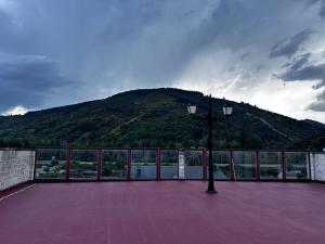 a building with a mountain in the background with a street light at La estación in Villafranca del Bierzo +2 photos