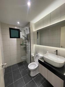 サイバージャヤにあるUrban Haven A modern retreat in condo cyberjayaのバスルーム(トイレ、シンク付)、テレビが備わります。