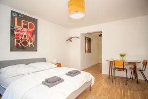 ein Schlafzimmer mit einem weißen Bett und einem Tisch und Stühlen in der Unterkunft Central Studio Apartment with free BaselCard - Magritte in Basel
