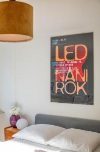 ein Schlafzimmer mit einem Bett mit einem Poster an der Wand in der Unterkunft Central Studio Apartment with free BaselCard - Magritte in Basel