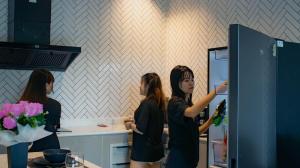 three women standing in a kitchen looking into a refrigerator at Private Sanctuary Yanui beach in Nai Harn Beach