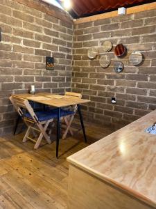 a dining room with a table and a brick wall at Cabaña en el bosque in Camotepec