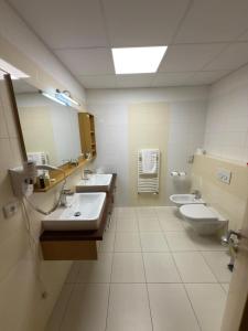 a bathroom with two sinks and two toilets at Penzión Siroň in Detva