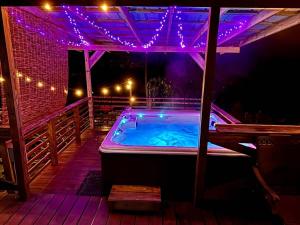 una vasca idromassaggio su una terrazza di notte di Creekside with views - jacuzzi firepit arcade a Cosby