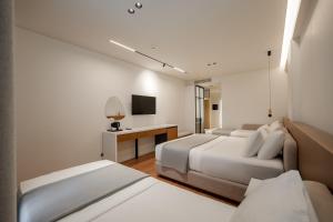 a hotel room with two beds and a television at Euro Hotel in Ksamil