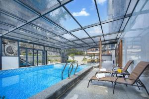 an indoor swimming pool with a glass ceiling at Yangshuo CheerMay Hotel in Yangshuo