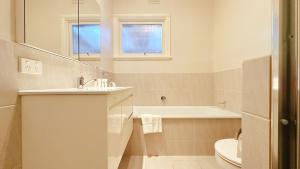 a bathroom with a tub and a sink and a toilet at Greenmeyer Retreat 3B1 and halfB by Goodlive in Briar Hill +38 photos