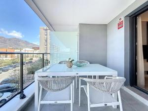 a white table and chairs in a room with a balcony at Hanami Luxury Apartment Connecta in Estepona