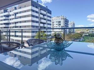 a glass table with chairs on a balcony with a building at Hanami Luxury Apartment Connecta in Estepona