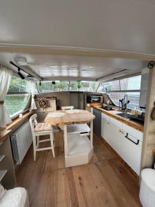 a kitchen with a table in the middle of a boat at Cocon sur l eau in Montargis