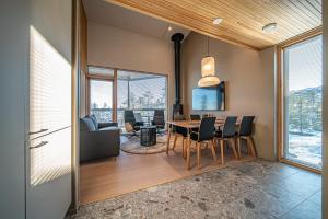 a dining room and living room with a table and chairs at Peak Chalet B6 Ski-in Ski-out by Aavalevi in Levi