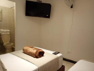una camera con un letto e una televisione a parete di Hotel Aerocafe Pereira a Pereira