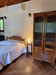 a bedroom with a bed and a wooden closet at Cozy Scenic Farmhouse Retreat in Mangalore