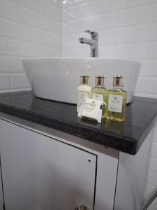 a bathroom counter with three bottles of oils on it at Cozy Scenic Farmhouse Retreat in Mangalore