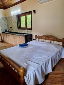 a bedroom with a large bed with a wooden frame at Cozy Scenic Farmhouse Retreat in Mangalore