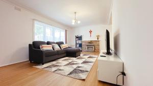 a living room with a couch and a television at Greenmeyer Retreat 3B1 and halfB by Goodlive in Briar Hill