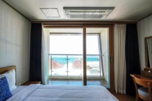 sypialnia z łóżkiem i widokiem na ocean w obiekcie Swansea Resort w mieście Czedżu