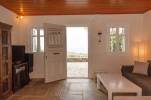 a living room with a door leading to a patio at Porto Blue Horizon in Agios Ioannis