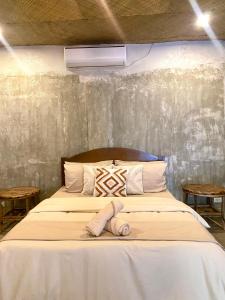 a bed with a stuffed animal sitting on top of it at Villa Rosa Siargao in General Luna