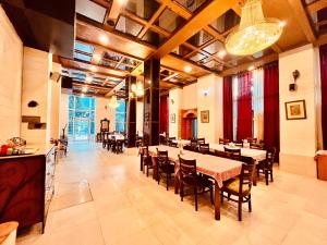 una sala da pranzo con tavoli, sedie e lampadario a braccio di The Town House - Lavish & Luxury Rooms Near mall Road Manali a Manāli