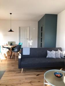 a living room with a blue couch and a table at MSF Apartment Green Wolf in Kassel