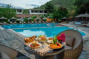 a table with food on it next to a swimming pool at Sultan Palas Otel in Köyceğiz