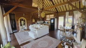 ein Wohnzimmer mit einer weißen Couch und einer Küche in der Unterkunft Serene Sunset Uluwatu in Uluwatu