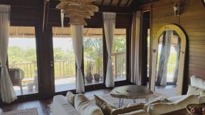 ein Wohnzimmer mit einer Couch und einigen Fenstern in der Unterkunft Serene Sunset Uluwatu in Uluwatu + 21 Fotos