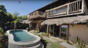 einem Pool vor einem Haus mit einem Gebäude in der Unterkunft Serene Sunset Uluwatu in Uluwatu