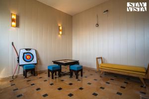 a room with a bench and a table with a target at StayVista at Echoes of Ease with Bonfire & WiFi in Rishīkesh