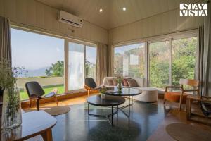 a living room with a couch and a table and chairs at StayVista at Echoes of Ease with Bonfire & WiFi in Rishīkesh