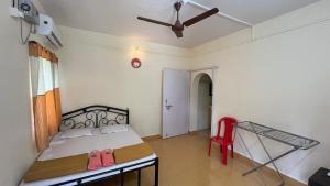 a bedroom with a bed and a red chair at Ritu Holiday Home - Nagaon in Nagaon